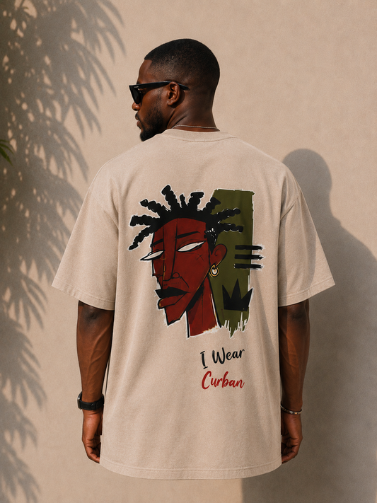 A man wearing a beige graphic t-shirt from the back, featuring a stylized illustration of a man with dreadlocks and the text 'I Wear Curban'.